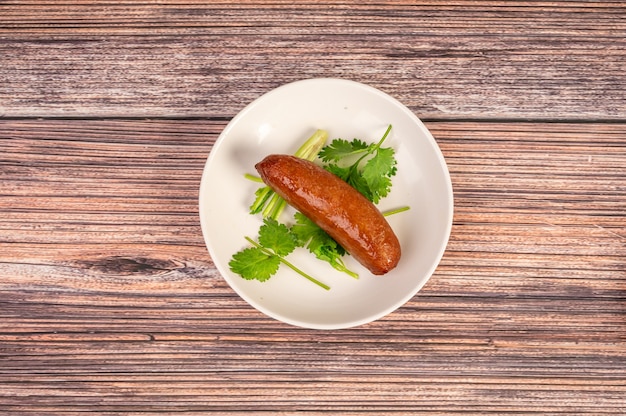 La cuisine chinoise, la saucisse dans l'assiette est sur la table en bois