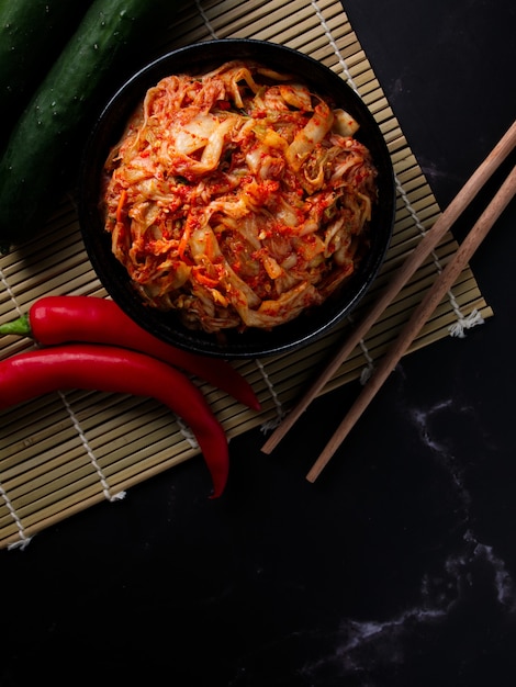 La cuisine coréenne, kimchi de chou dans un plat noir sur fond sombre.