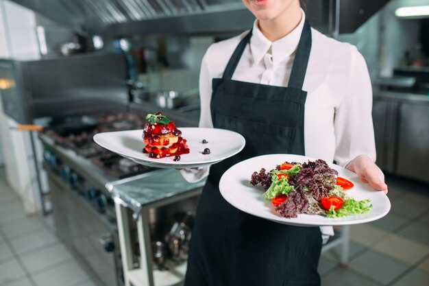 Photo cuisine du restaurant. garçon avec un plat de foie gras prêt à poser posant dans la cuisine.