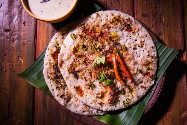 Cuisine du sud de l'Inde Uttapam ou ooththappam ou Uthappa est un plat de type dosa préparé en cuisinant des ingrédients dans une pâte, servi avec du chutney de noix de coco, du chutney vert et du sambar