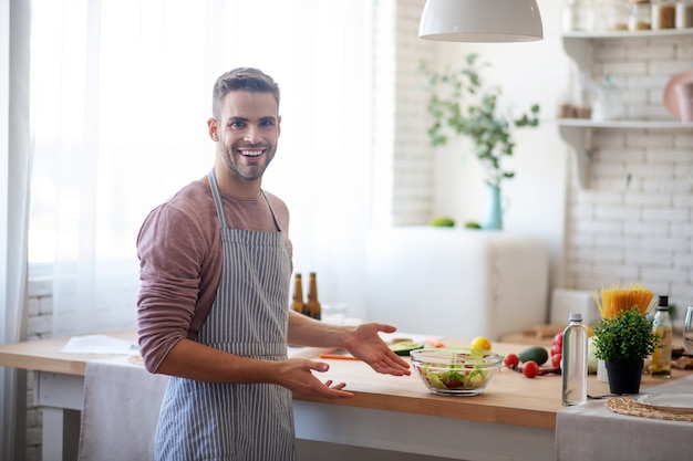 La cuisine est intéressante. Un homme prépare un déjeuner sain par lui-même