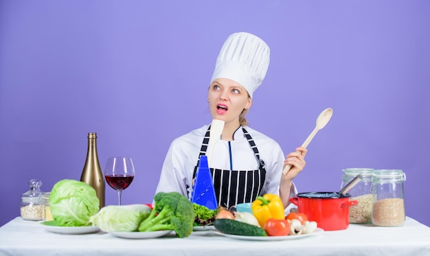 La cuisine est son passe-temps Cuisiner des aliments sains Fille en chapeau et tablier Femme chef cuisinant des aliments sains Ingrédients de légumes frais pour la cuisson des repas Concept de recette délicieuse Recettes de plats principaux gastronomiques