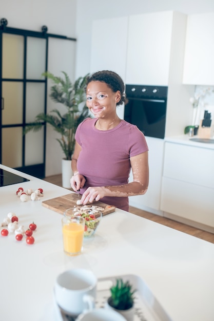 Cuisine. Une femme à la peau foncée cuisinant dans la cuisine et coupant des légumes