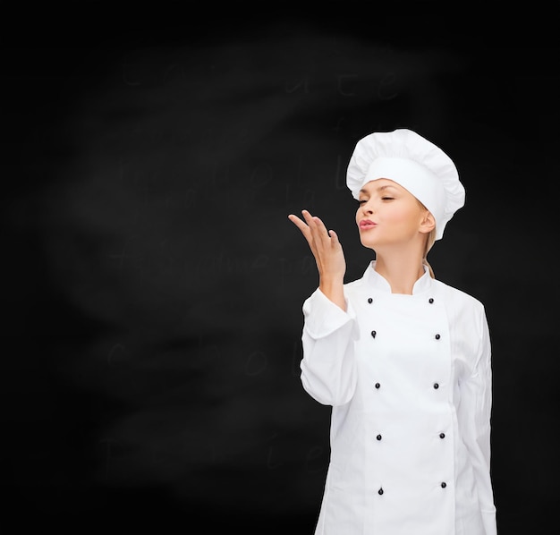 cuisine, geste et concept alimentaire - femme chef souriante montrant un geste délicieux
