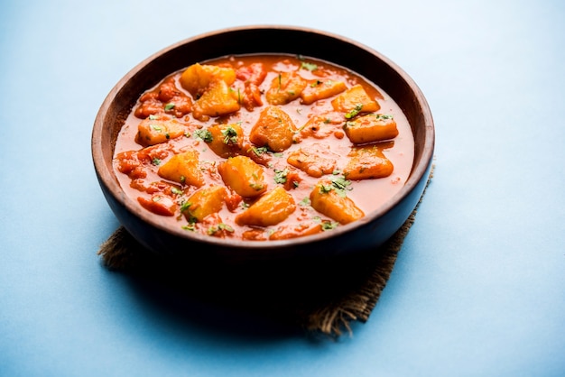 Cuisine indienne - Aloo curry masala. Pomme de terre cuite avec des épices et des herbes dans un curry de tomates. servi dans un bol sur fond de mauvaise humeur. mise au point sélective
