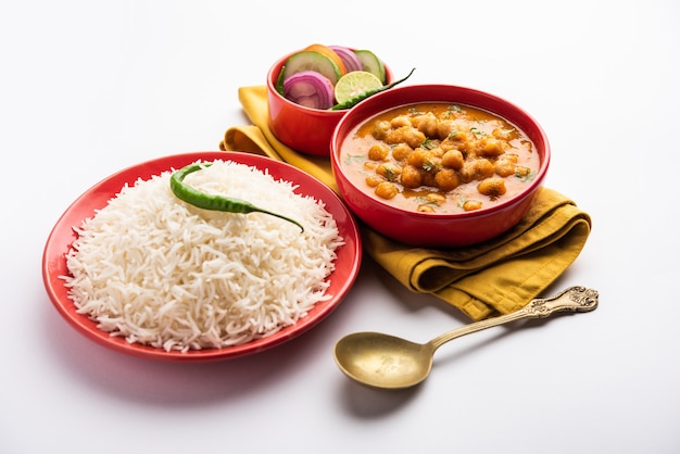 Cuisine indienne chole chawal ou curry de pois chiches épicé avec riz nature servi avec salade verte. mise au point sélective