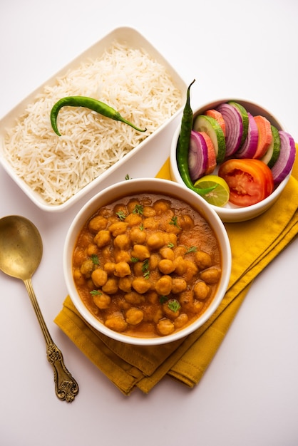 Cuisine indienne chole chawal ou curry de pois chiches épicé avec riz nature servi avec salade verte