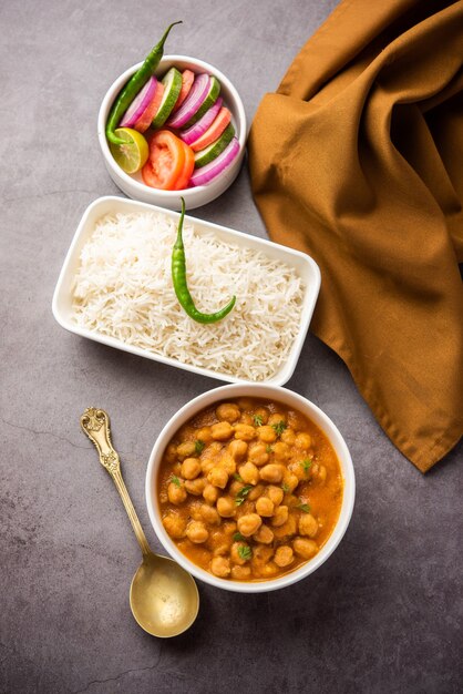 Cuisine indienne chole chawal ou curry de pois chiches épicé avec riz nature servi avec salade verte