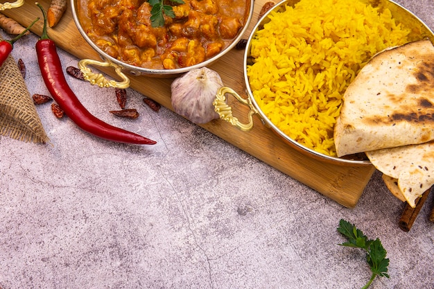 Cuisine indienne. Poulet au curry à la sauce tomate et riz jaune, copy space