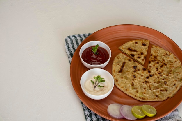 Cuisine indienne traditionnelle Aloo paratha ou pain plat farci de pommes de terre. servi avec du ketchup aux tomates