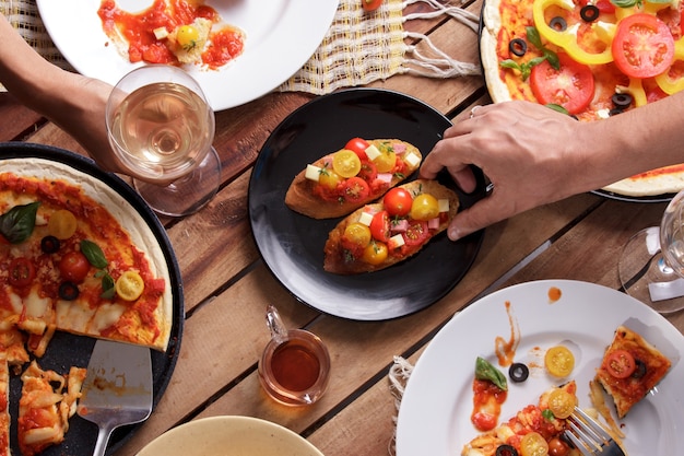 Une cuisine italienne sur table en bois avec des mains humaines