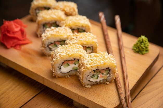 La cuisine japonaise roule avec de la sauce sur une assiette en bois