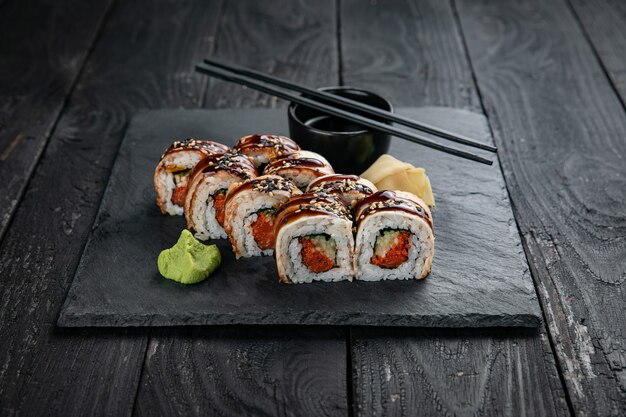 Cuisine japonaise Rouleaux sur une assiette carrée sur une table noire