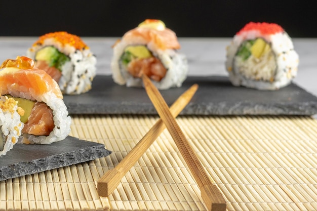 Cuisine japonaise Sushi placé sur une assiette noire accompagnée de sauce et de baguettes Mise au point sélective