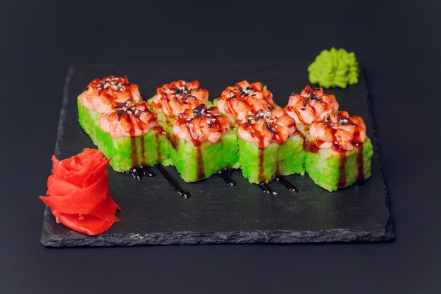 Cuisine japonaise traditionnelle Mélanger des sushis colorésEnsemble de différents types de rouleaux de sushi avec crevettes saumon et légumes Sur fond rustique noir Vue de dessus