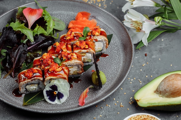 Cuisine japonaise traditionnelle. Rouleaux de sushi à l'anguille sur une table grise.