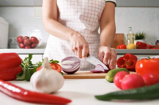 Cuisine maison. Femme, cuisine, couper, oignons rouges