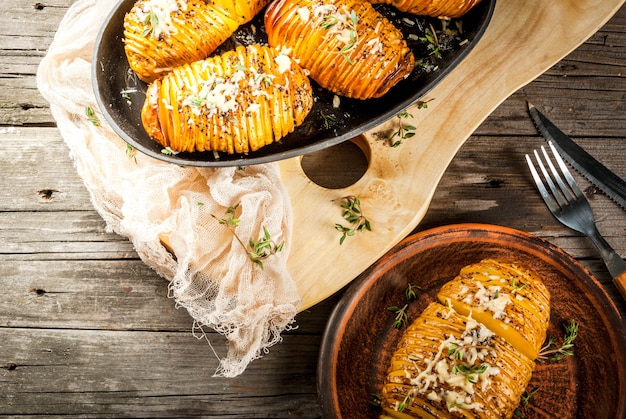 Cuisine maison traditionnelle américaine. Le régime végétalien. Pomme de terre Hasselback maison avec des herbes fraîches et du fromage.