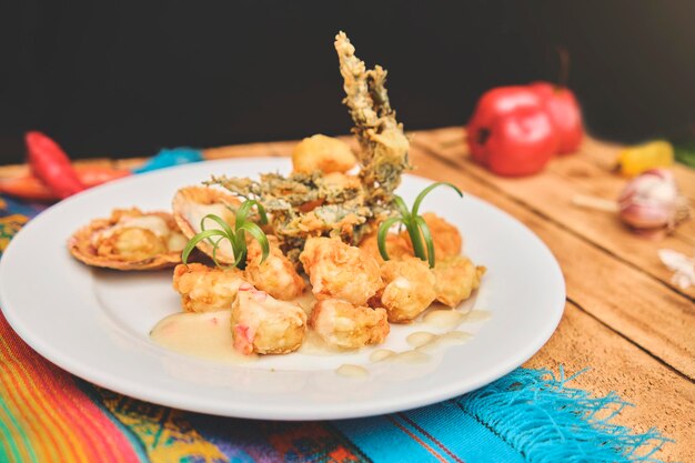 Cuisine péruvienne Crevettes sautées aux herbes et à l'ail table en bois servie sur une assiette blanche