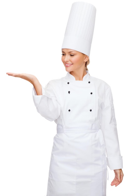 cuisine, publicité et concept alimentaire - femme chef souriante tenant quelque chose sur la paume de la main