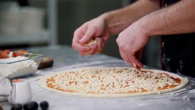 Cuisine de restaurant un chef mettant du fromage sur la pizza