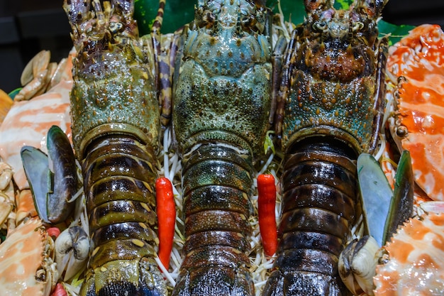 Cuisine de rue chinoise. Commerce de rue. Sortes chinoises de fruits de mer frais sur un marché asiatique de fruits de mer à Sanya, province de Hainan, Chine. Inscription : nom de la nourriture.