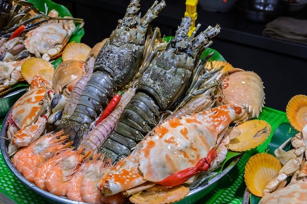 Cuisine de rue chinoise. Commerce de rue. Sortes chinoises de fruits de mer frais sur un marché asiatique de fruits de mer à Sanya, province de Hainan, Chine. Inscription : nom de la nourriture.