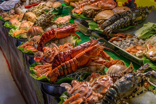 Cuisine de rue chinoise. Commerce de rue. Sortes chinoises de fruits de mer frais sur un marché asiatique de fruits de mer à Sanya, province de Hainan, Chine. Inscription : nom de la nourriture.