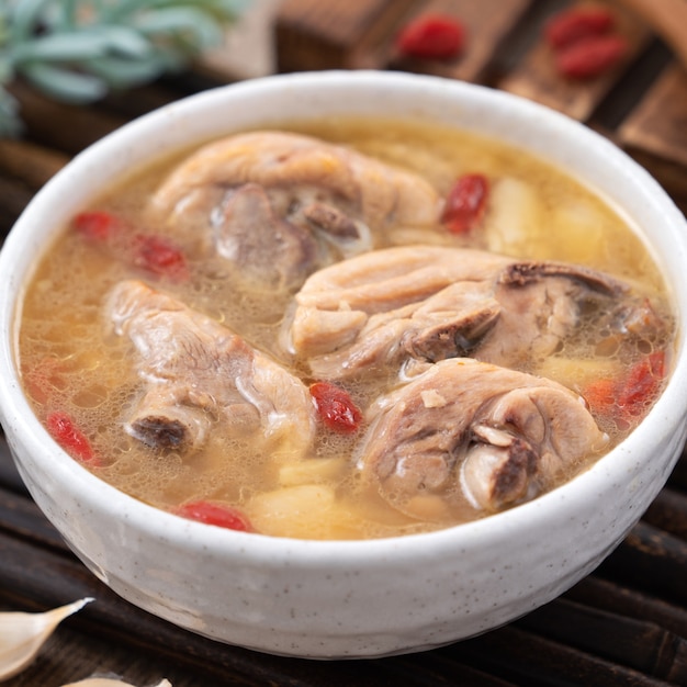 Cuisine taïwanaise - délicieuse soupe au poulet à l'ail fait maison dans un bol sur fond de table en bois foncé.