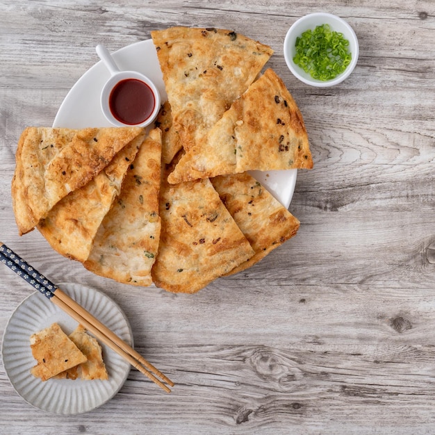 Cuisine taïwanaise délicieuses crêpes feuilletées de tarte aux oignons verts sur fond de table en bois clair collation traditionnelle en vue de dessus de Taïwan