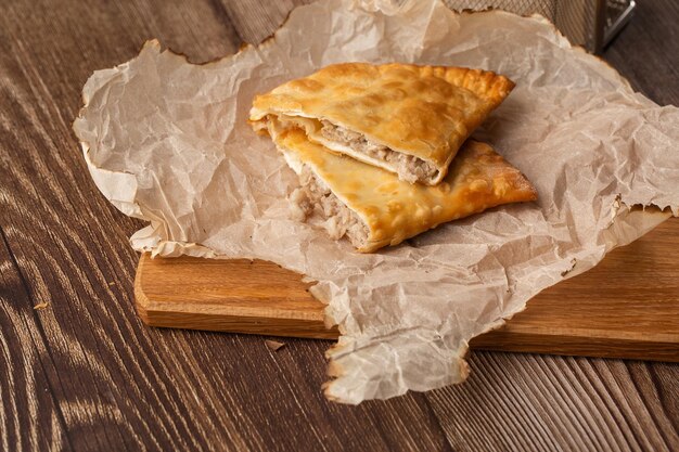 Cuisine tatare orientale ouzbèke cheburek sur une planche de bois Tarte frite Cheburek avec de la viande Plat traditionnel d'empanadas turques et mongolianpasties