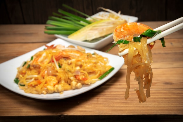 Cuisine thaïlandaise célèbre appelée pad thai sur une plaque blanche