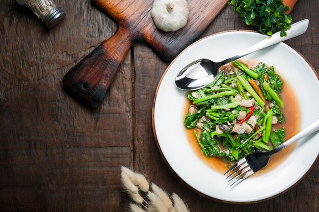 Cuisine thaïlandaise: Chou frit au poisson salé séché au soleil sur une table en bois