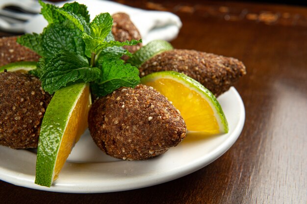 Cuisine traditionnelle du Moyen-Orient. Cuisine libanaise. Kibbeh arabe avec des tranches d'orange