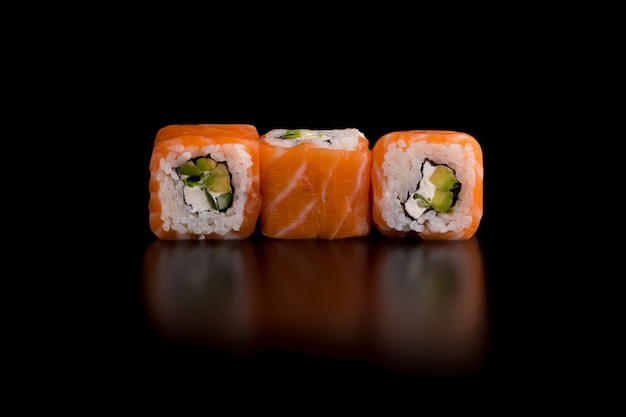 Cuisine traditionnelle japonaise - sushi avec avocat, riz, fromage cottage, saumon et oignon vert