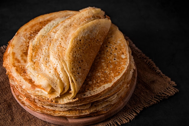 Cuisine traditionnelle russe fines crêpes Une pile de crêpes sur un fond de bois brun foncé