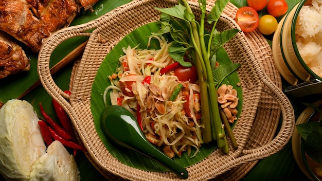 Cuisine traditionnelle thaïlandaise Somtum ou salade de papaye avec riz gluant au poulet grillé à la thaïlandaise et légumes