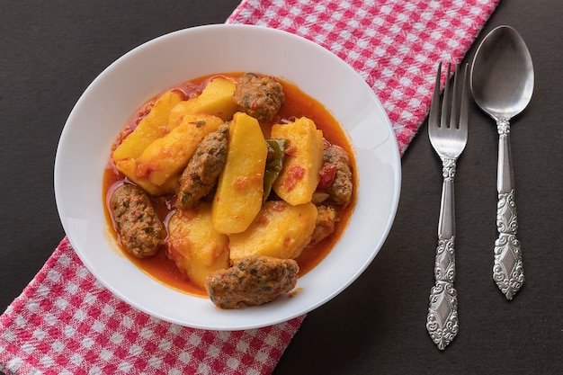 Cuisine turque traditionnelle faite maison Kofte - Kofta avec sauce tomate et pommes de terre. (nom turc; Izmir kofte)