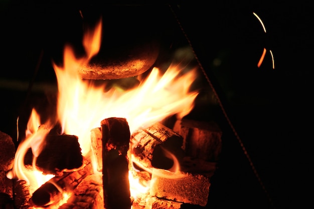 Cuisiner sur le bûcher la nuit. Grosse flamme