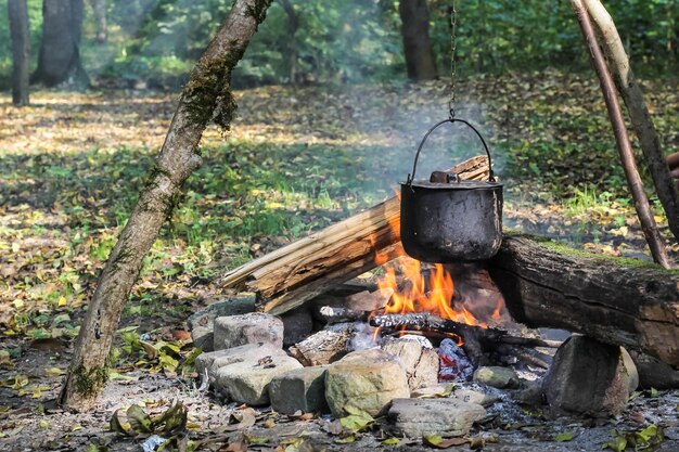 Cuisiner dans la nature. Chaudron en feu dans la forêt