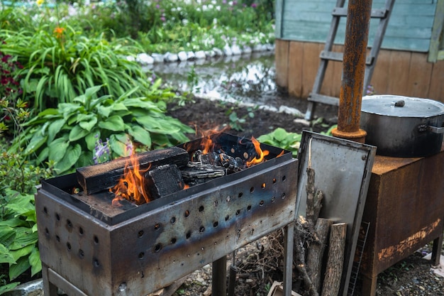 Cuisiner sur un gril dans des ustensiles de cuisson en fonte à l'extérieur Des pommes de terre avec du lard