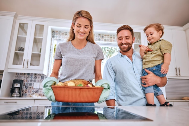 Cuisiner les parents et l'enfant heureux avec un repas pour le dîner dans la cuisine de leur maison Turquie Thanksgiving et mère et père avec enfant et sourire pour la nourriture familiale Noël ou déjeuner sur la cuisinière