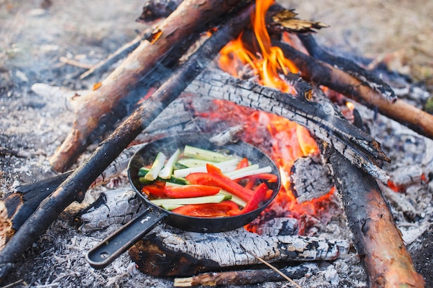 Cuisiner des plats de poivrons rouges et de concombres dans une casserole au feu