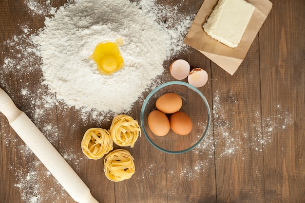 Cuisiner des plats savoureux. Avec des ingrédients comme du beurre, des œufs, de la farine, des pâtes. Vue d'en-haut