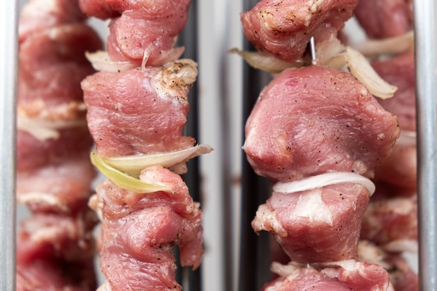 Cuisiner de la viande de porc dans une machine à kebab électrique sur des brochettes verticales