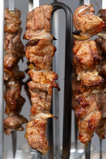 Cuisiner de la viande de porc dans une machine à kebab électrique sur des brochettes verticales