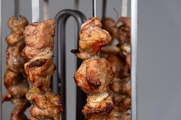 Cuisiner de la viande de porc dans une machine à kebab électrique sur des brochettes verticales