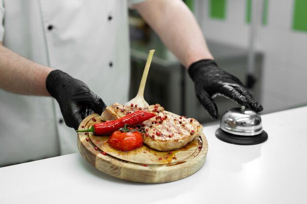 Cuisinez avec un plat préparé avec de la viande et des légumes sur une planche en bois.