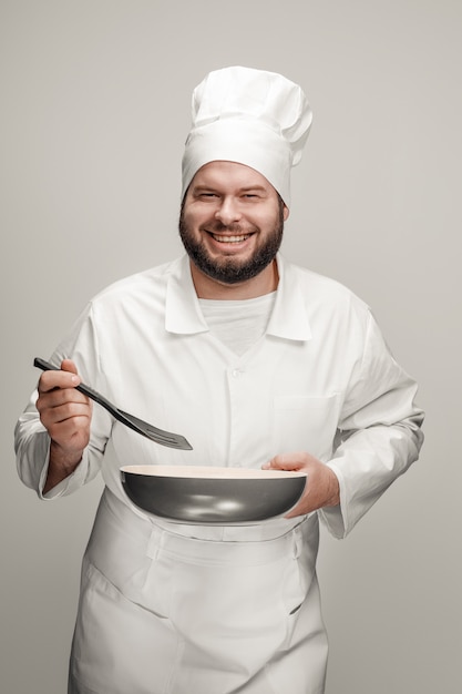 Cuisinier excité avec poêle et spatule