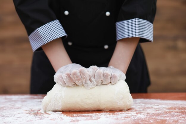 Le cuisinier fait de la farine à partir de farine pour la cuisson sur la table